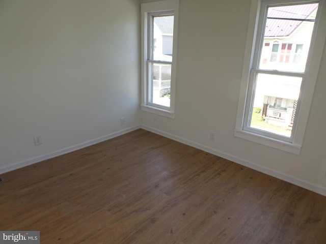 unfurnished room with dark wood finished floors and baseboards