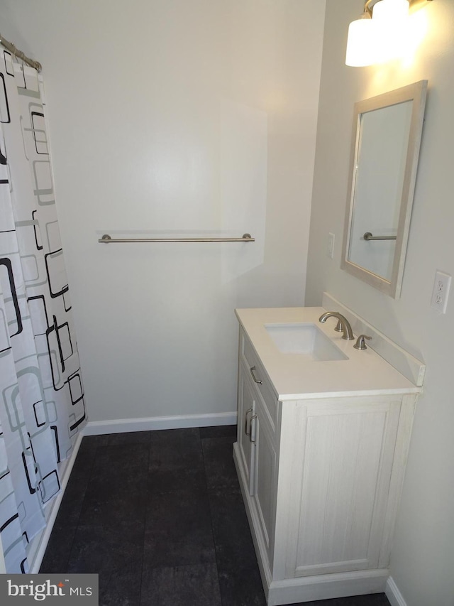 full bath featuring baseboards and vanity