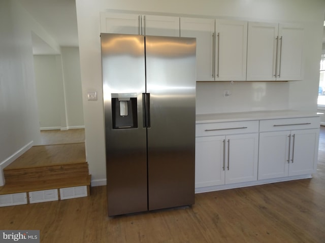 kitchen featuring dark wood-style flooring, white cabinets, light countertops, and stainless steel fridge with ice dispenser