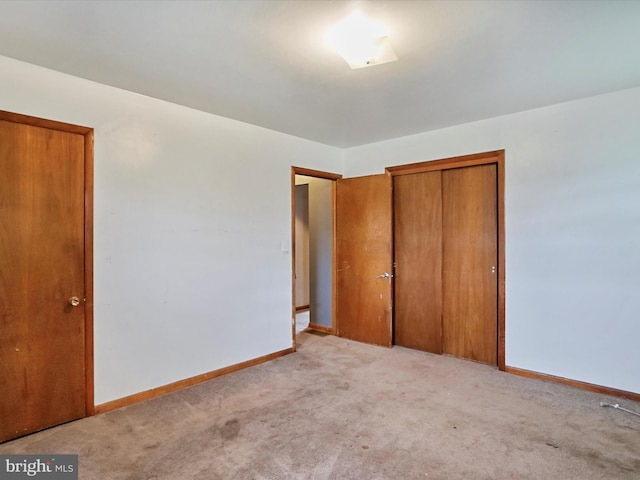 unfurnished bedroom with light carpet and a closet