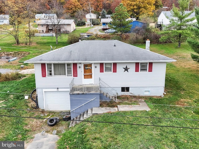 bi-level home featuring a garage and a front yard