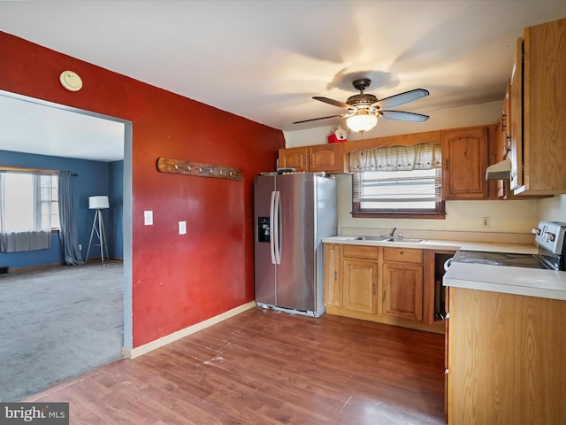 kitchen with light hardwood / wood-style floors, white stove, sink, ceiling fan, and stainless steel fridge