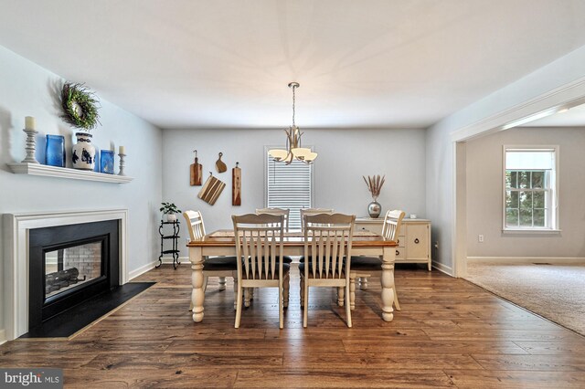 dining area featuring an inviting chandelier and dark wood-type flooring