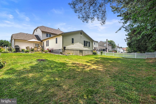 rear view of house featuring a yard