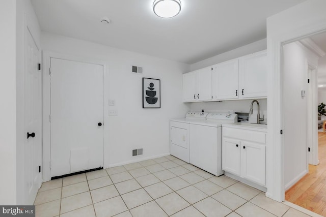 washroom featuring cabinets, washer and clothes dryer, sink, and light tile patterned flooring