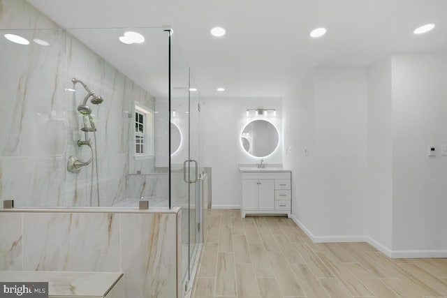 bathroom with hardwood / wood-style flooring, a shower with door, and vanity