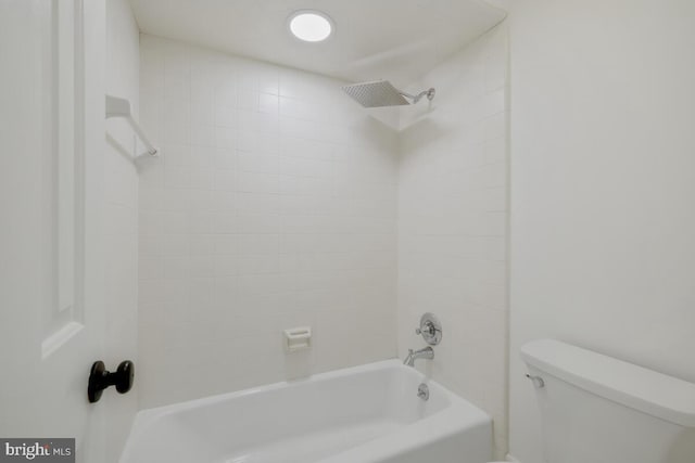 bathroom with toilet and tiled shower / bath combo