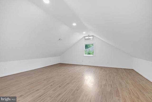 additional living space featuring light hardwood / wood-style flooring and vaulted ceiling