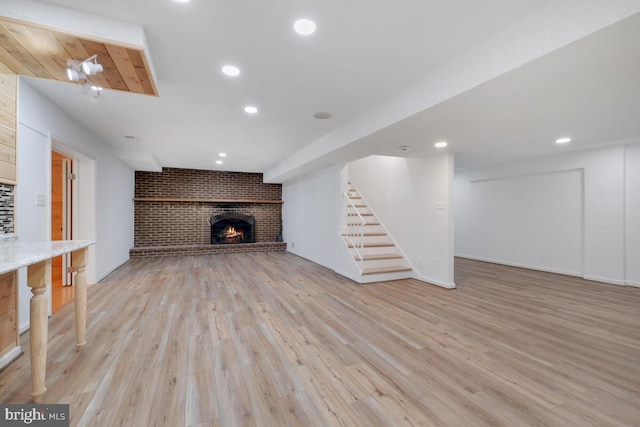 unfurnished living room featuring a fireplace and light hardwood / wood-style floors