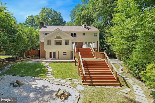 rear view of house featuring a yard and a patio