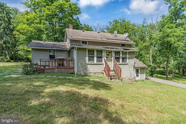 rear view of property featuring a lawn