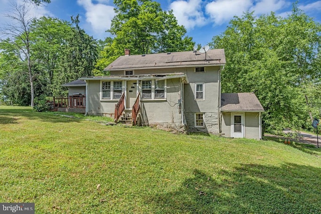 rear view of property featuring a wooden deck and a yard