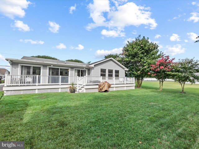 rear view of house featuring a deck and a lawn