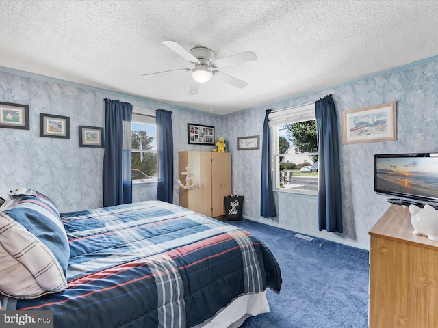 carpeted bedroom featuring a textured ceiling and ceiling fan