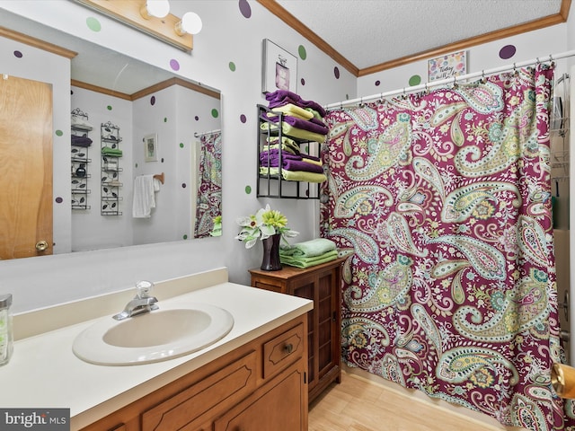 bathroom featuring vanity, a shower with curtain, ornamental molding, a textured ceiling, and wood-type flooring