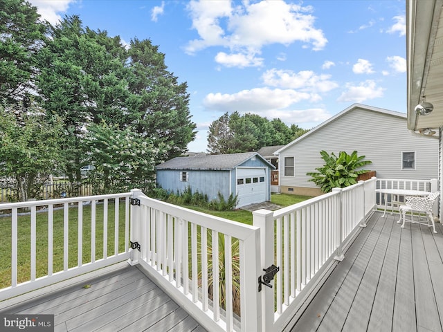 wooden terrace with a garage, an outbuilding, and a yard