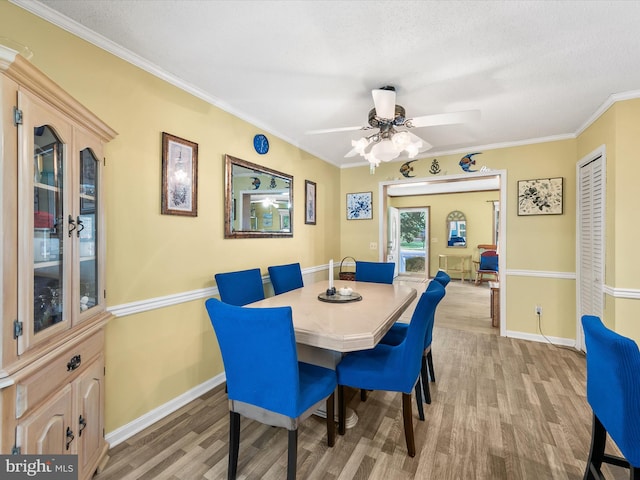 dining area featuring a textured ceiling, light hardwood / wood-style flooring, ceiling fan, and ornamental molding