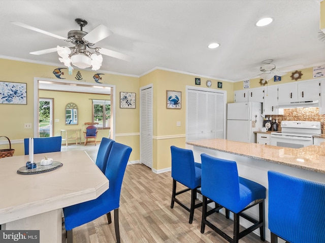 kitchen with white cabinetry, light wood-type flooring, white appliances, and crown molding