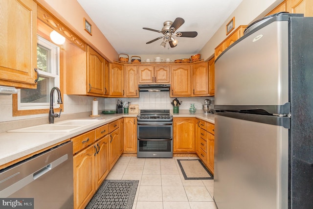 kitchen with light tile patterned flooring, tasteful backsplash, ceiling fan, stainless steel appliances, and sink