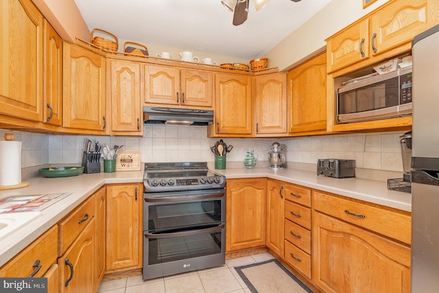 kitchen with ceiling fan, appliances with stainless steel finishes, tasteful backsplash, and light tile patterned floors