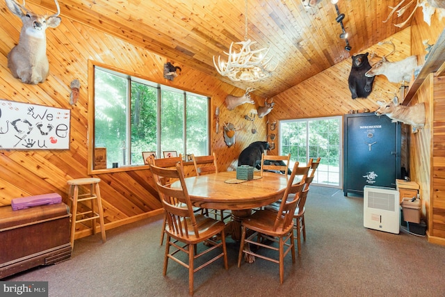 dining space featuring a notable chandelier, carpet floors, vaulted ceiling, wood walls, and wood ceiling