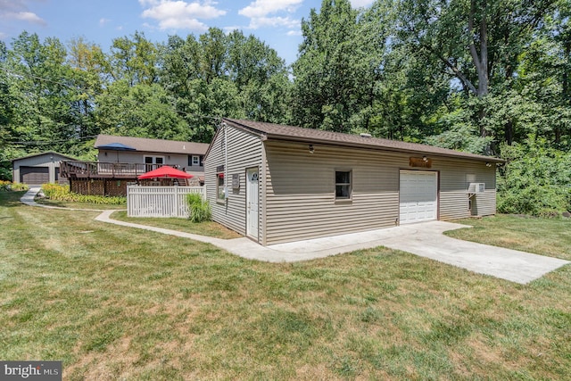 view of front facade with a garage, an outdoor structure, a front lawn, and a deck