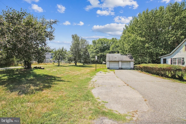 view of yard featuring a garage and an outdoor structure