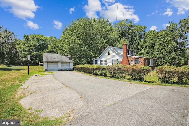 view of front facade with a garage, an outdoor structure, and a front yard