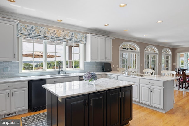 kitchen featuring white cabinetry, a center island, and sink