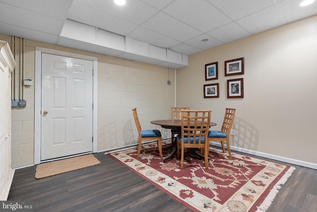 dining room with dark hardwood / wood-style flooring and a drop ceiling