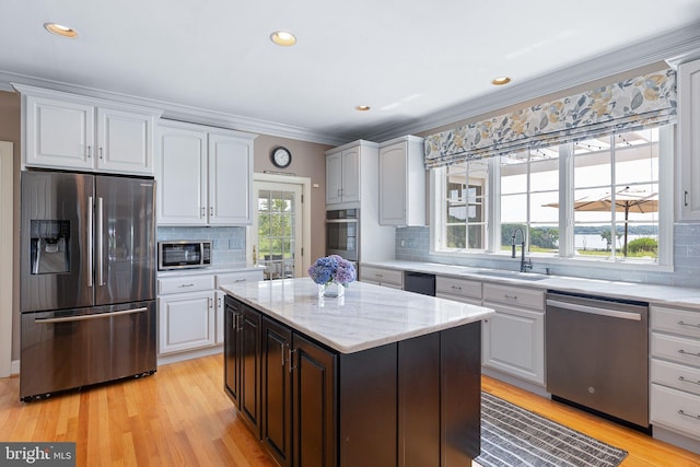 kitchen featuring tasteful backsplash, stainless steel appliances, crown molding, sink, and white cabinets