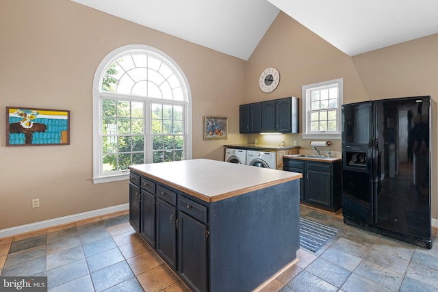 kitchen with lofted ceiling, sink, washing machine and dryer, a kitchen island, and black fridge with ice dispenser