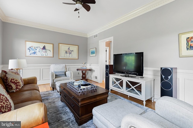 living room featuring hardwood / wood-style flooring, ceiling fan, and crown molding