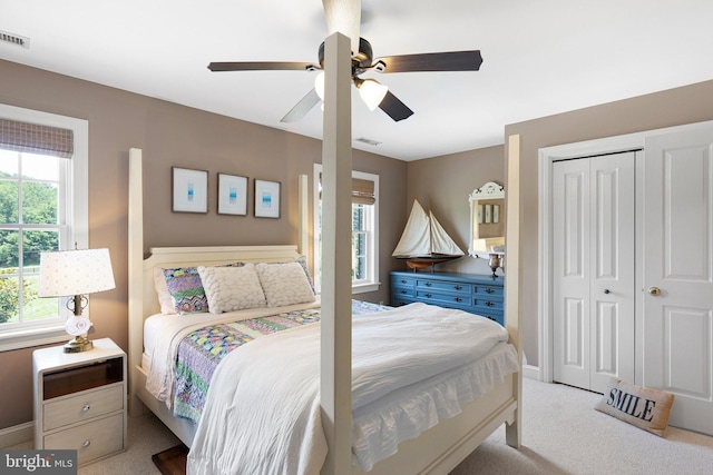 carpeted bedroom featuring ceiling fan and a closet