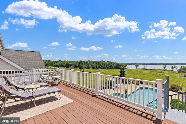 wooden deck featuring a fenced in pool and a water view