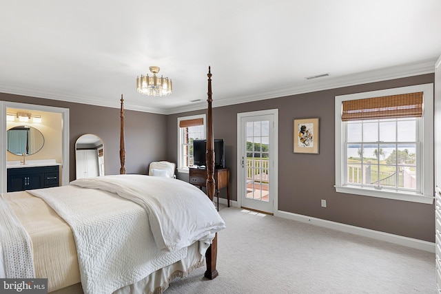 carpeted bedroom featuring an inviting chandelier, crown molding, access to outside, and ensuite bath