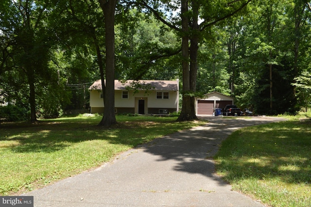 view of front of property with a garage, an outbuilding, and a front lawn