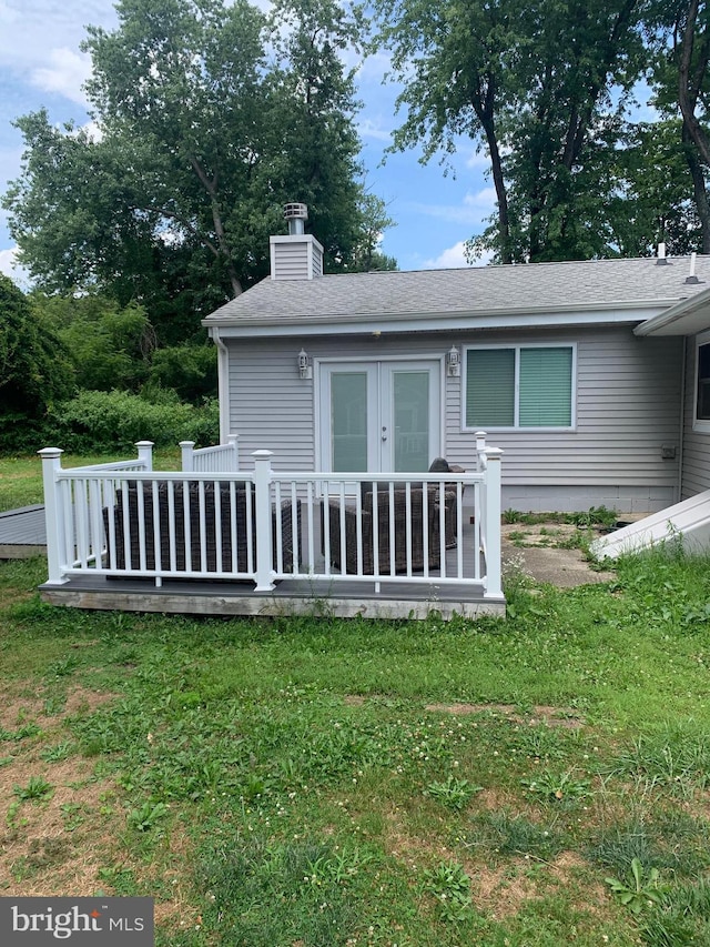 back of house with french doors, a deck, and a lawn