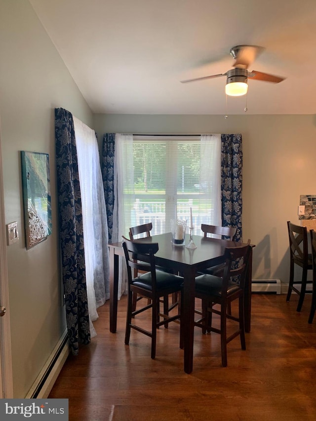 dining space featuring a baseboard heating unit, ceiling fan, and dark wood-type flooring