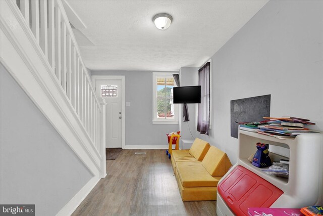 living room with a textured ceiling and hardwood / wood-style flooring