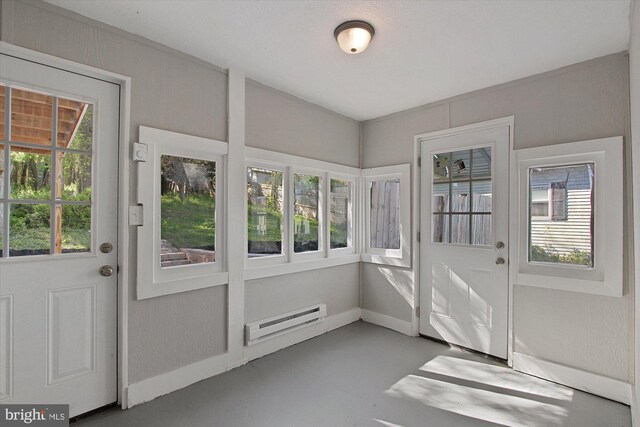 doorway to outside with concrete floors and a baseboard heating unit