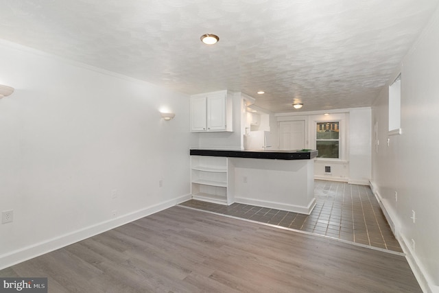 28 N 4th St, Steelton, PA 17113 - kitchen featuring dark hardwood / wood-style floors, white fridge, a breakfast bar, kitchen peninsula, and white cabinets