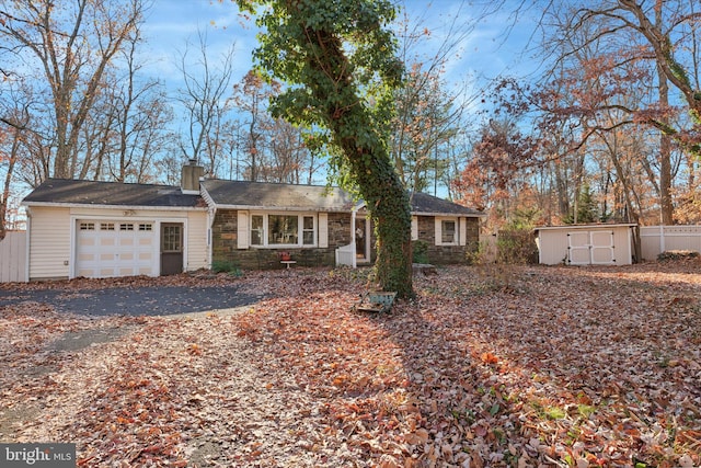 single story home featuring a shed and a garage