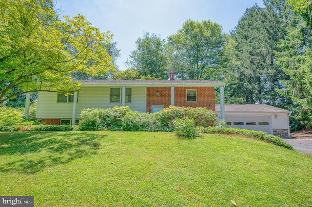 split foyer home with an attached garage, a front yard, and driveway