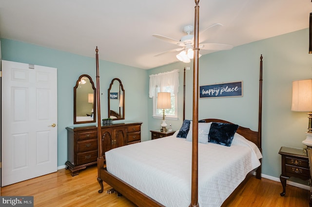 bedroom featuring wood finished floors, baseboards, and a ceiling fan