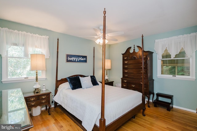 bedroom featuring wood finished floors, multiple windows, and ceiling fan