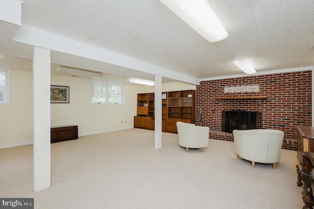 basement with a brick fireplace, carpet floors, and baseboards