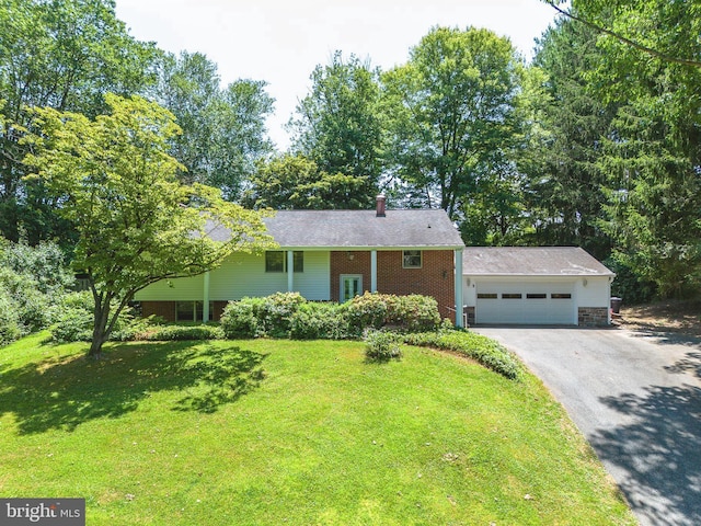single story home featuring driveway, a front yard, a garage, brick siding, and a chimney