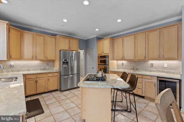 kitchen with appliances with stainless steel finishes, a kitchen breakfast bar, backsplash, sink, and a center island