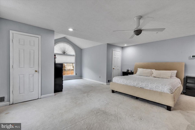 carpeted bedroom featuring ceiling fan, lofted ceiling, and a textured ceiling